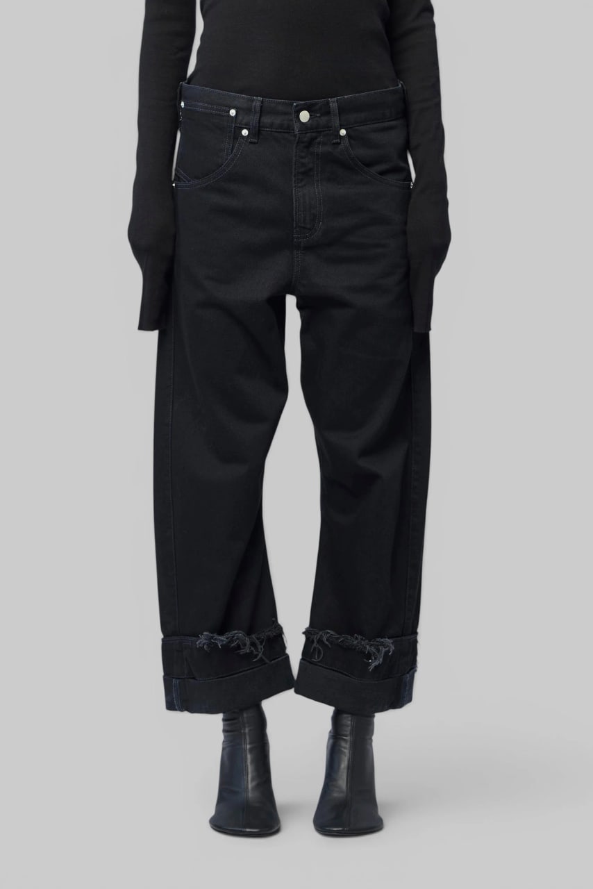 The wide-leg jeans from the front, the hems turned up into deep, frayed cuffs.