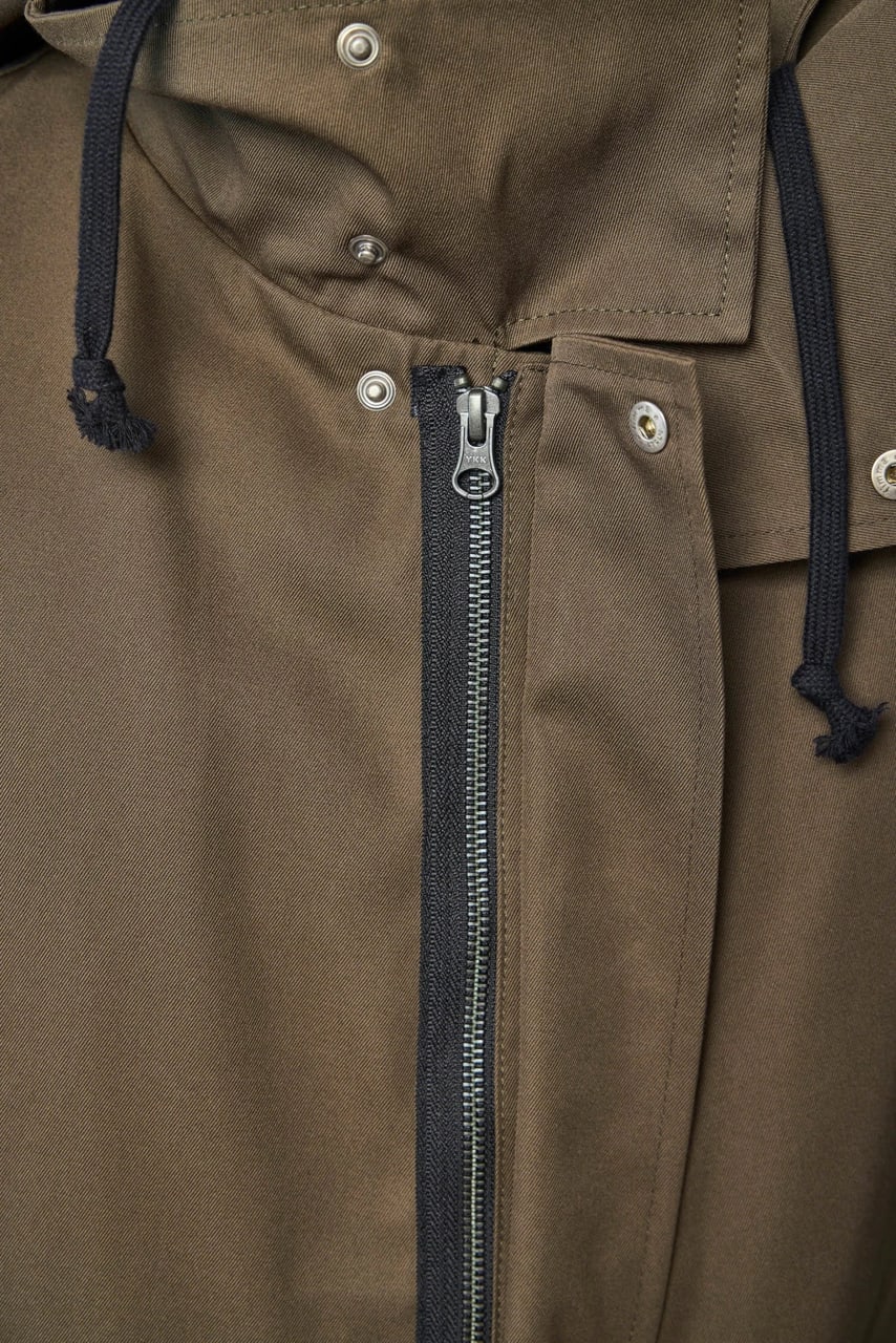 The parka’s front: a long zip, press studs and black drawcords at the collar.